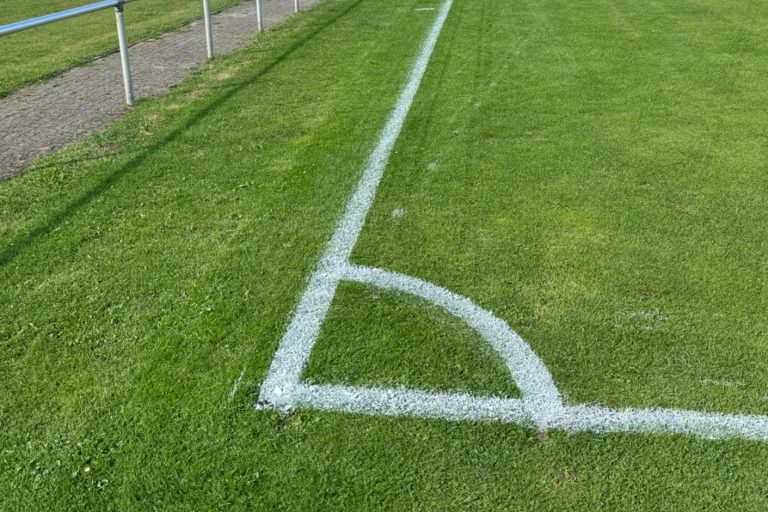Frisch markierte Ecklinie auf einem Fußballplatz mit sauber gezogener Spielfeldbegrenzung